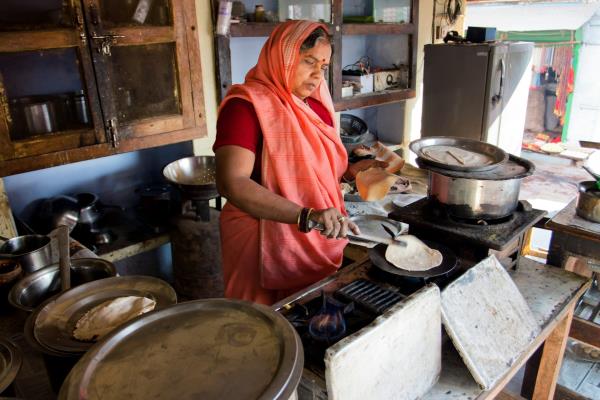 An Indian woman cooks a chapati