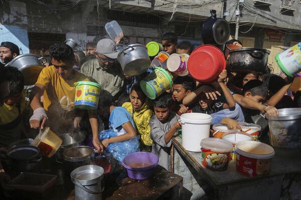 Palestinians crowded together as they wait for food distribution in Rafah, southern Gaza Strip, on Wednesday. (Picture: AP Photo/Hatem Ali, File)